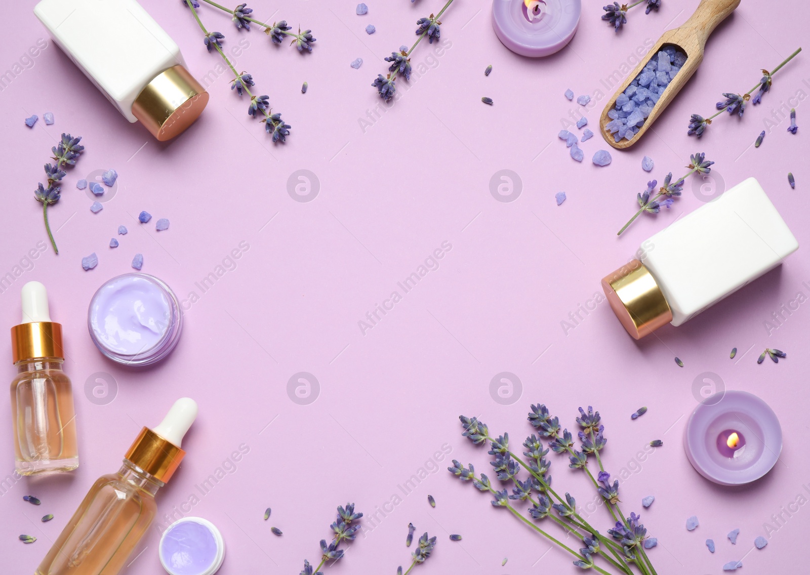 Photo of Frame made with lavender flowers and natural cosmetic products on pink background. Space for text