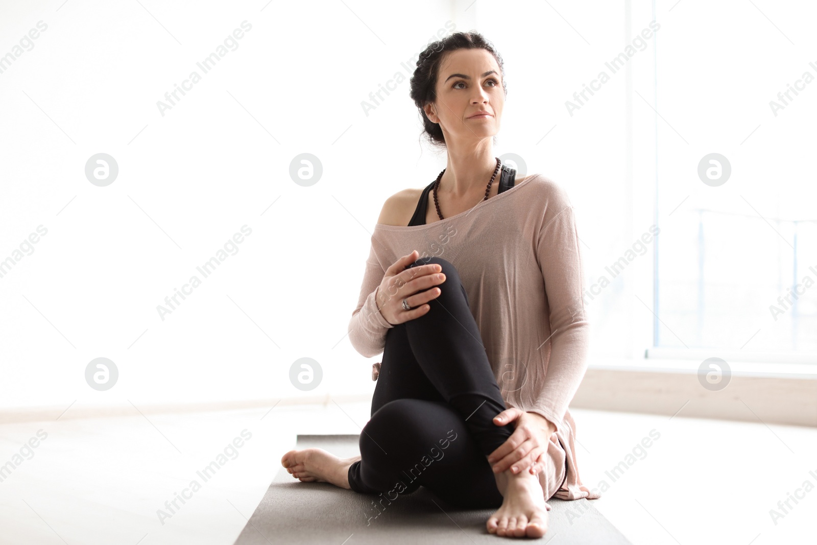 Photo of Sporty woman practicing yoga indoors