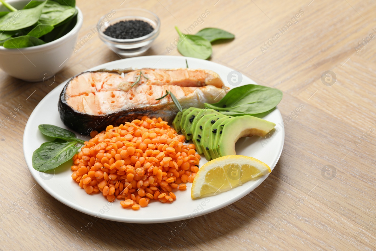 Photo of Plate with healthy food high in vegetable fats on wooden table, closeup. Space for text