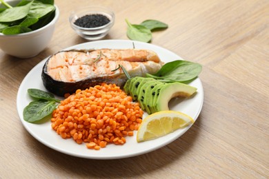 Photo of Plate with healthy food high in vegetable fats on wooden table, closeup. Space for text