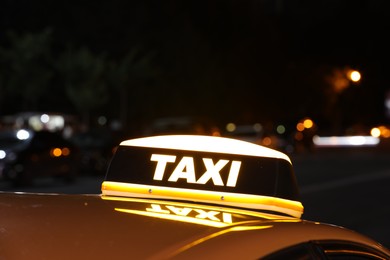 Photo of Taxi car with yellow sign outdoors at night