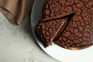 Delicious chocolate truffle cake on grey table, top view