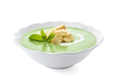 Green pea soup with croutons in bowl on white background