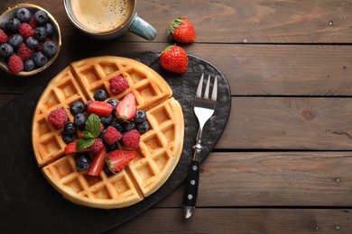 Photo of Tasty Belgian waffle with fresh berries served on wooden table, flat lay. Space for text