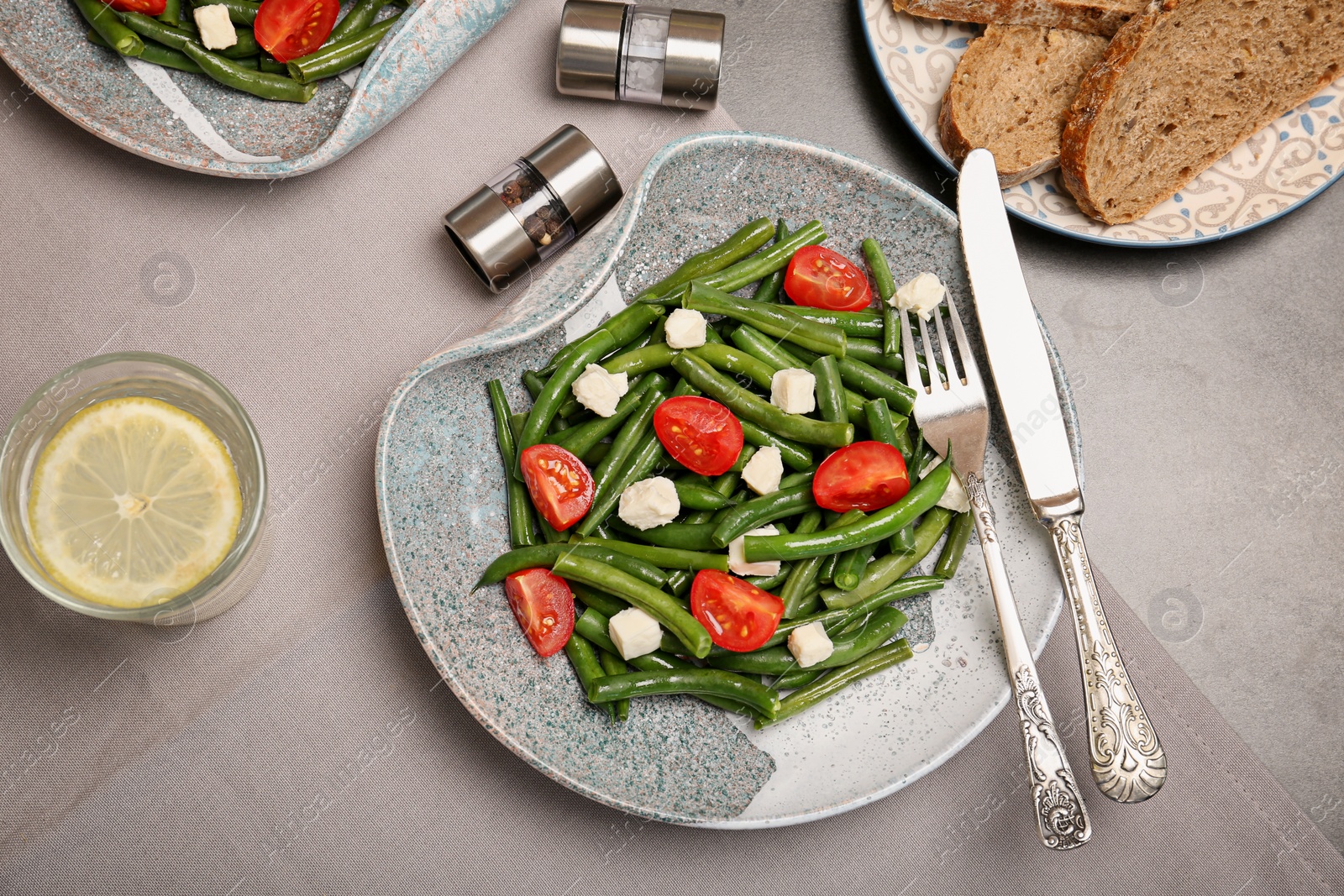 Photo of Plate with tasty green beans, tomatoes and cheese on table, top view