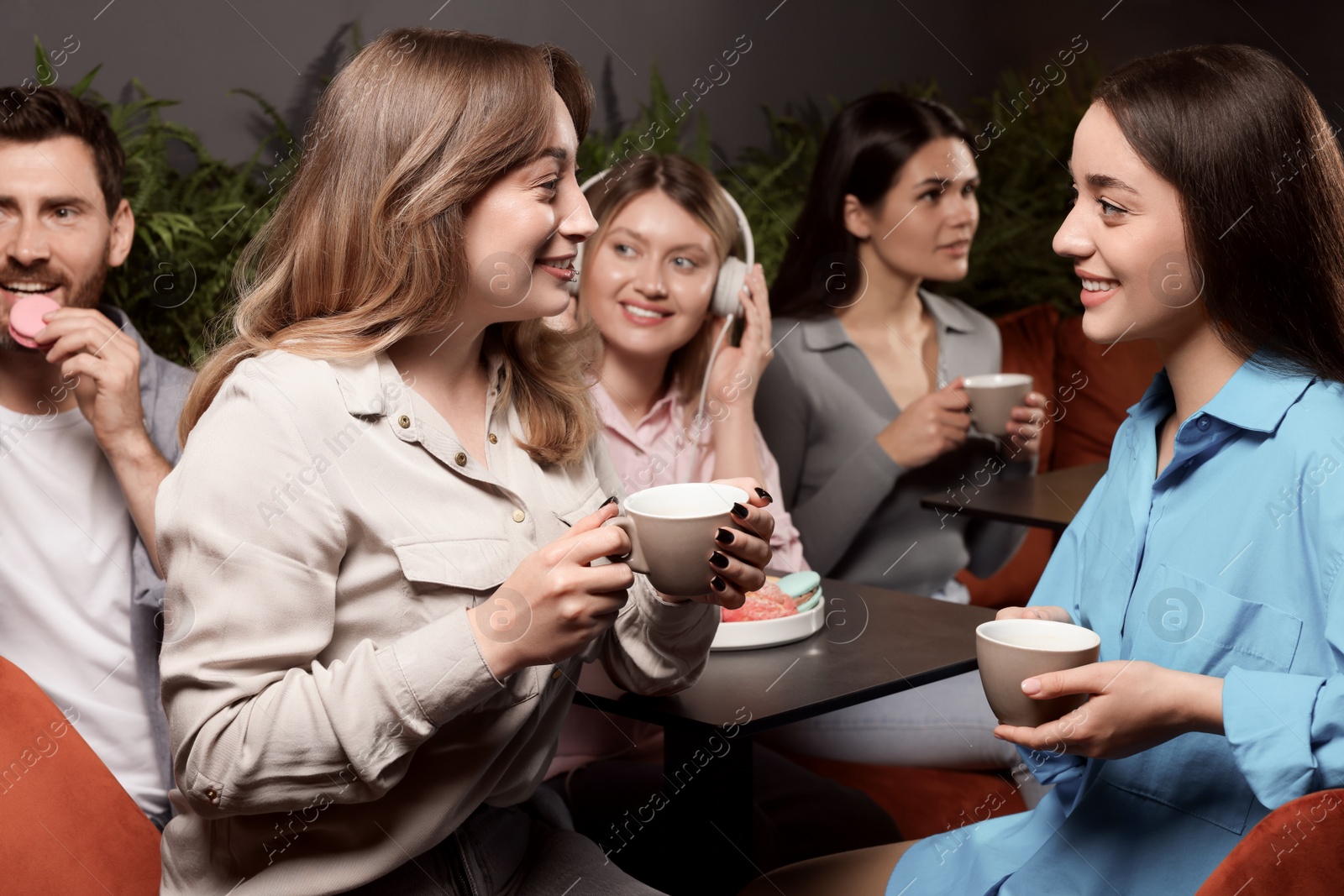 Photo of Friends with coffee spending time together in cafe