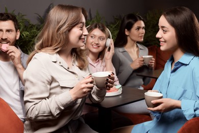 Photo of Friends with coffee spending time together in cafe