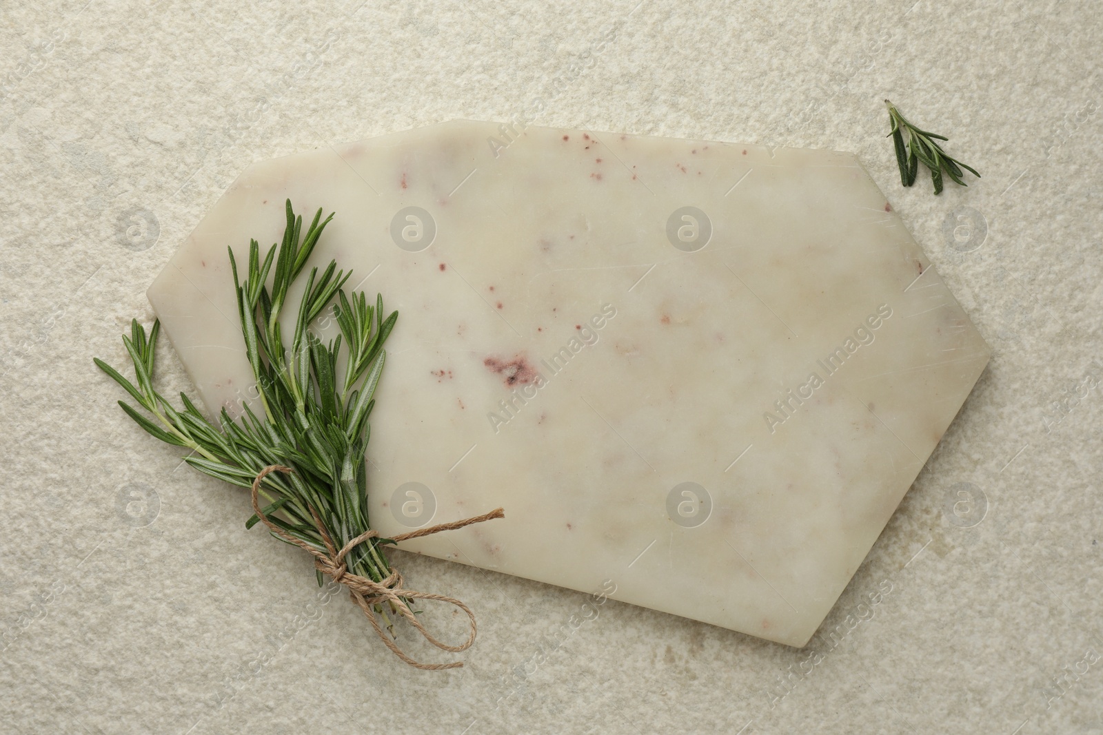 Photo of Cutting board and rosemary on white textured table, flat lay. Space for text