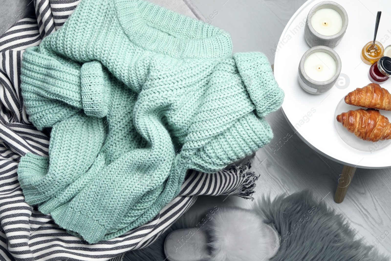 Photo of Light green knitted sweater at home, flat lay