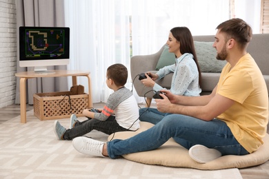 Photo of Happy family playing video games at home. Space for text