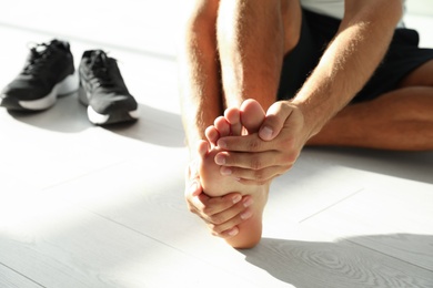 Photo of Man suffering from foot pain indoors, closeup. Space for text