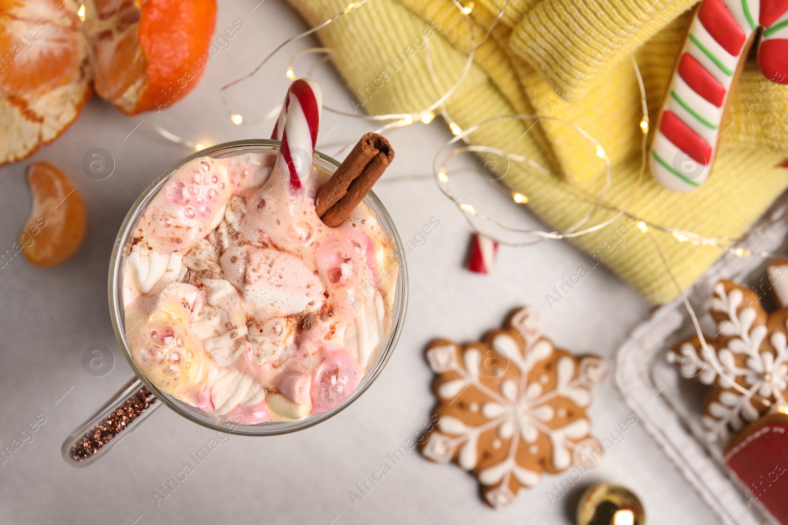 Photo of Flat lay composition with delicious marshmallow drink, festive items and yellow sweater on light table