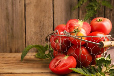 Fresh ripe tomatoes with leaves on wooden table