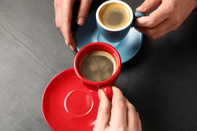 Women having coffee break at dark textured table, above view