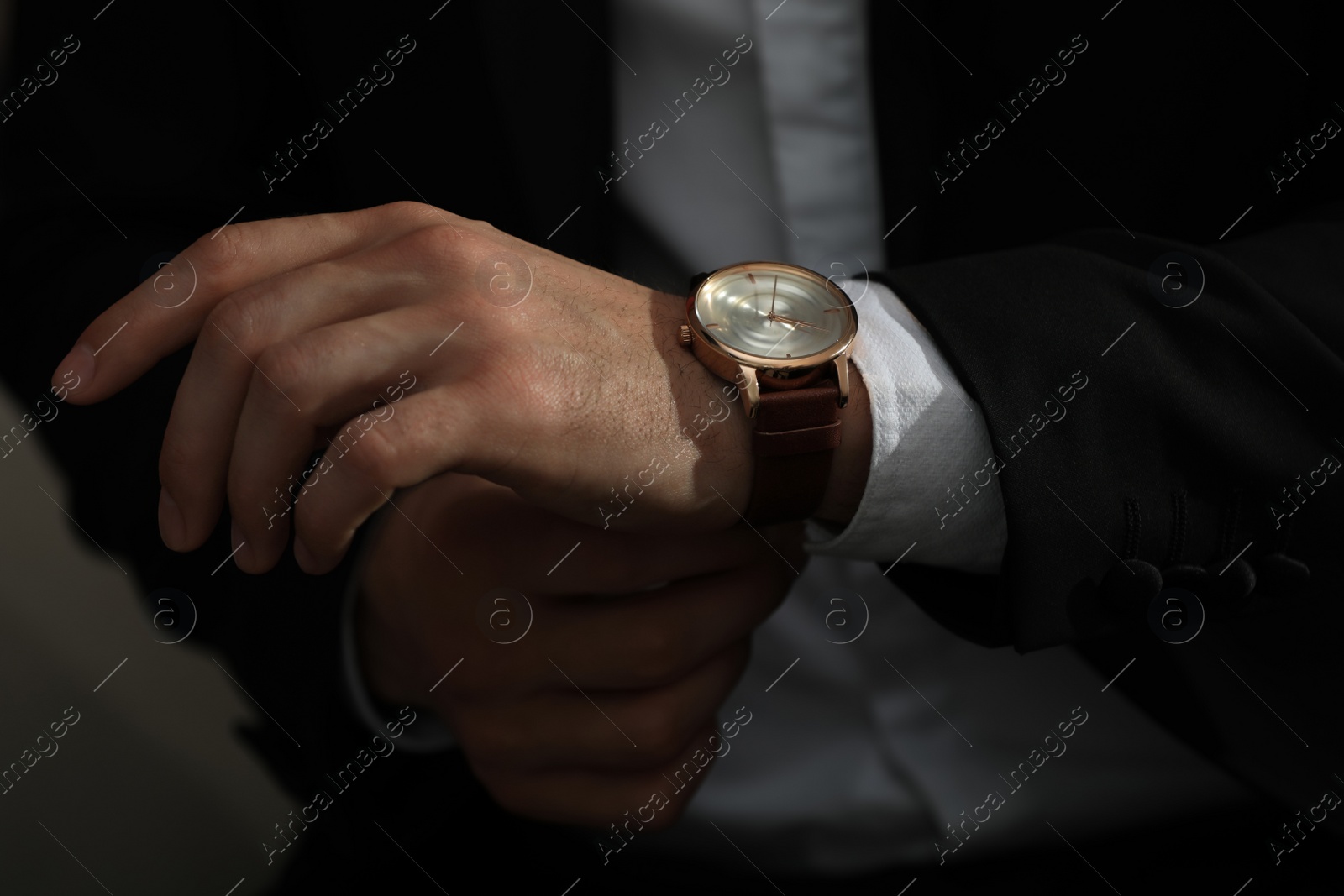 Photo of Man wearing luxury wrist watch on blurred background, closeup