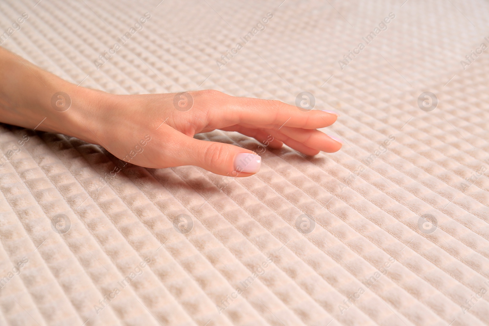 Photo of Woman touching soft beige fabric, closeup view