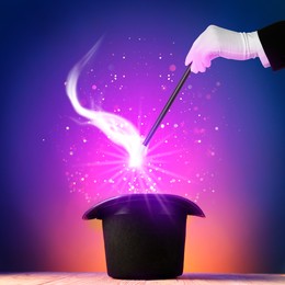 Wizard conjuring magical light out of hat with wand on color background, closeup