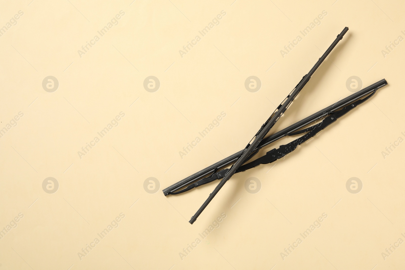 Photo of Car windshield wipers on beige background, flat lay. Space for text