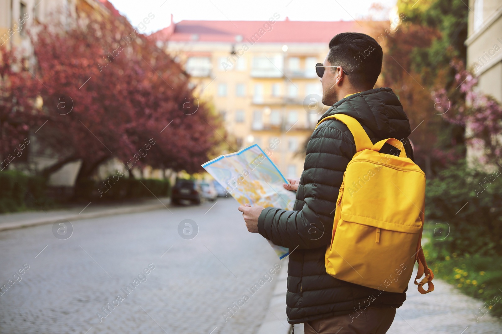 Photo of Male tourist with map on city street