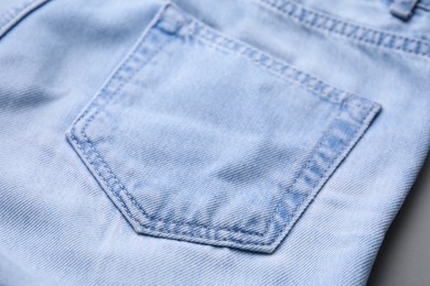 Photo of Jeans with pocket on grey background, closeup