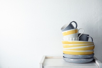 Set of dinnerware on table against light background with space for text. Interior element