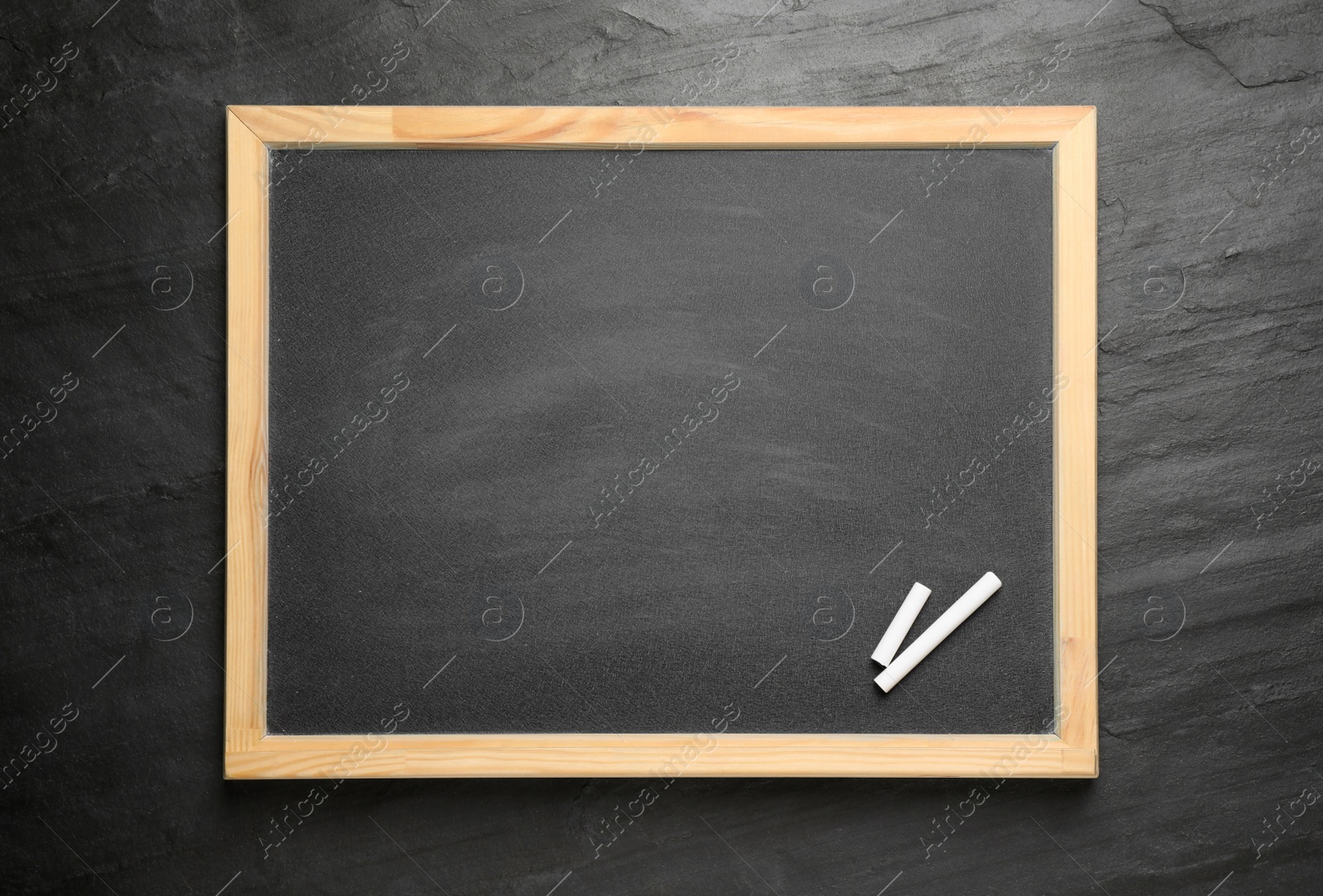 Photo of Empty blackboard with chalk on slate background, top view. Space for text