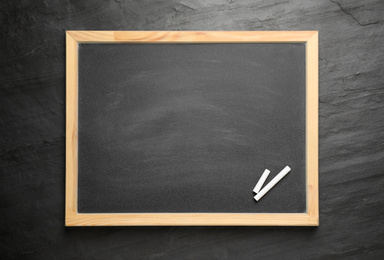 Photo of Empty blackboard with chalk on slate background, top view. Space for text