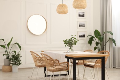 Photo of Stylish dining room with cozy furniture, mirror and plants