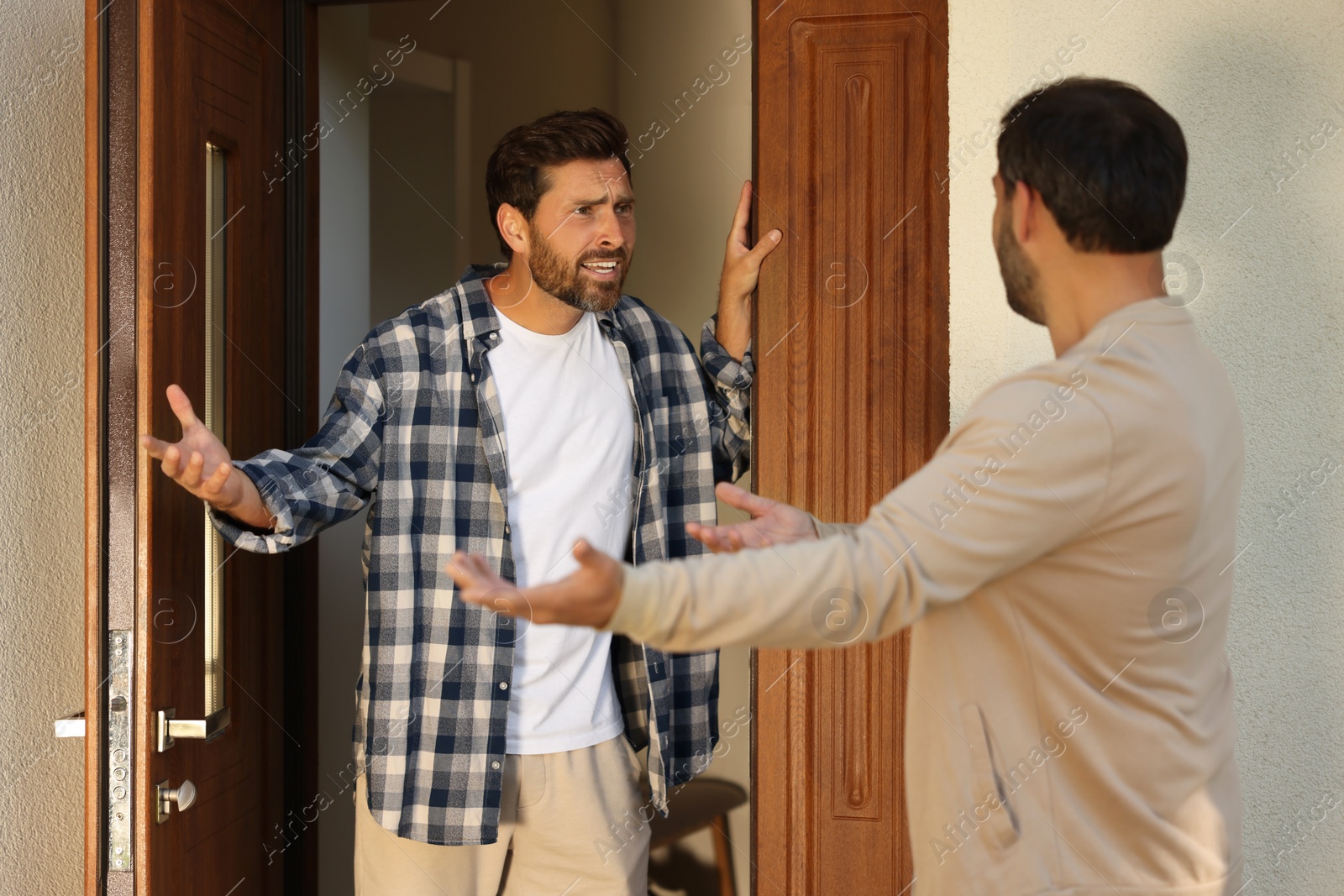 Photo of Emotional neighbours having argument near house outdoors