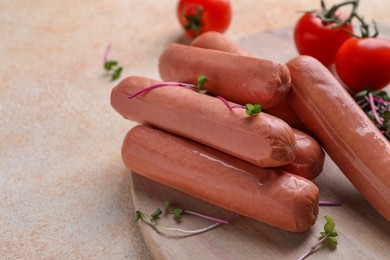 Photo of Tasty vegan sausages and products on beige table, closeup. Space for text