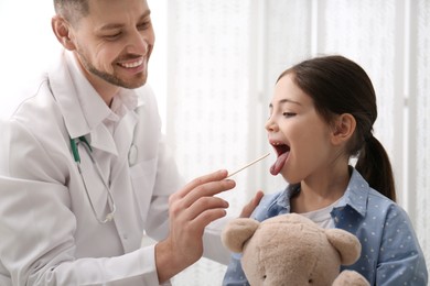 Pediatrician examining little girl in office at hospital