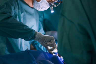 Photo of Professional doctors performing 
operation in surgery room, closeup