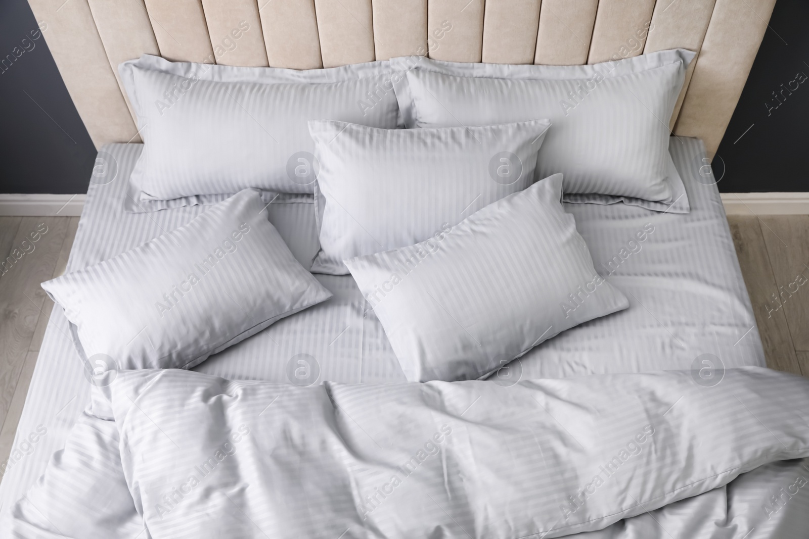 Photo of Comfortable bed with soft blanket and pillows indoors