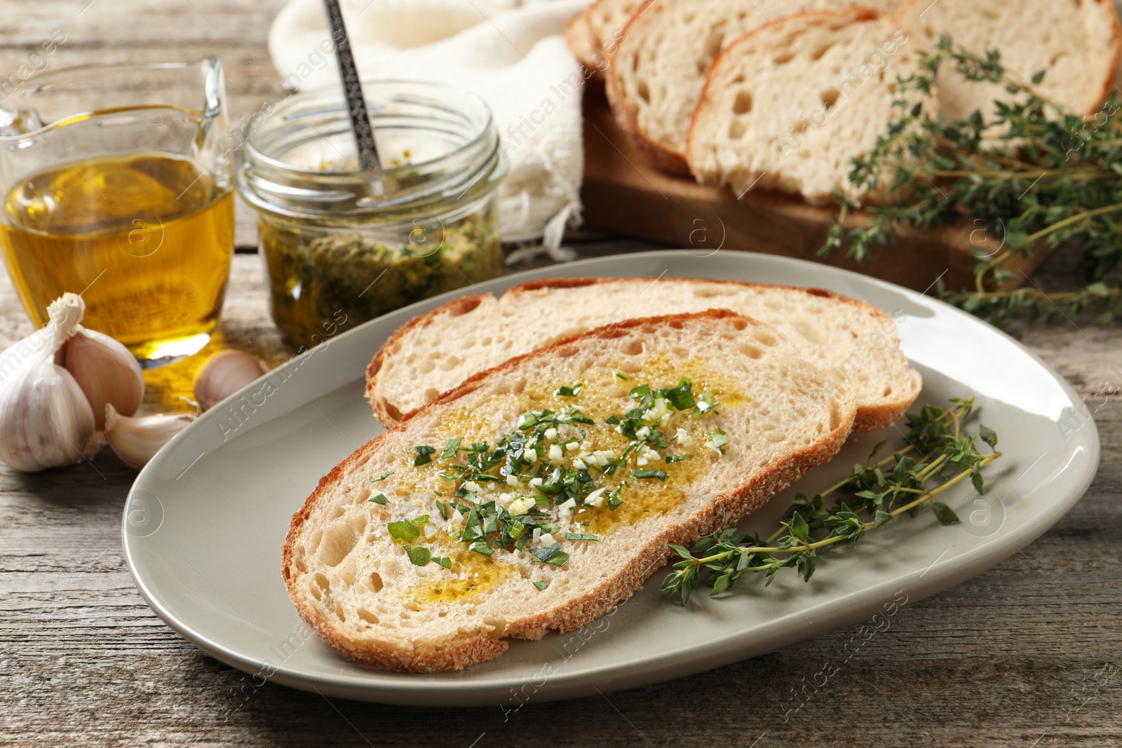 Photo of Tasty bruschettas with oil and garlic on wooden table