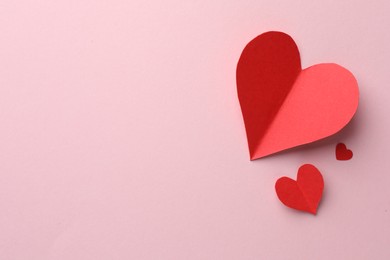 Photo of Paper hearts on pink background, flat lay. Space for text