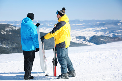 Friends with equipment on hill. Winter vacation