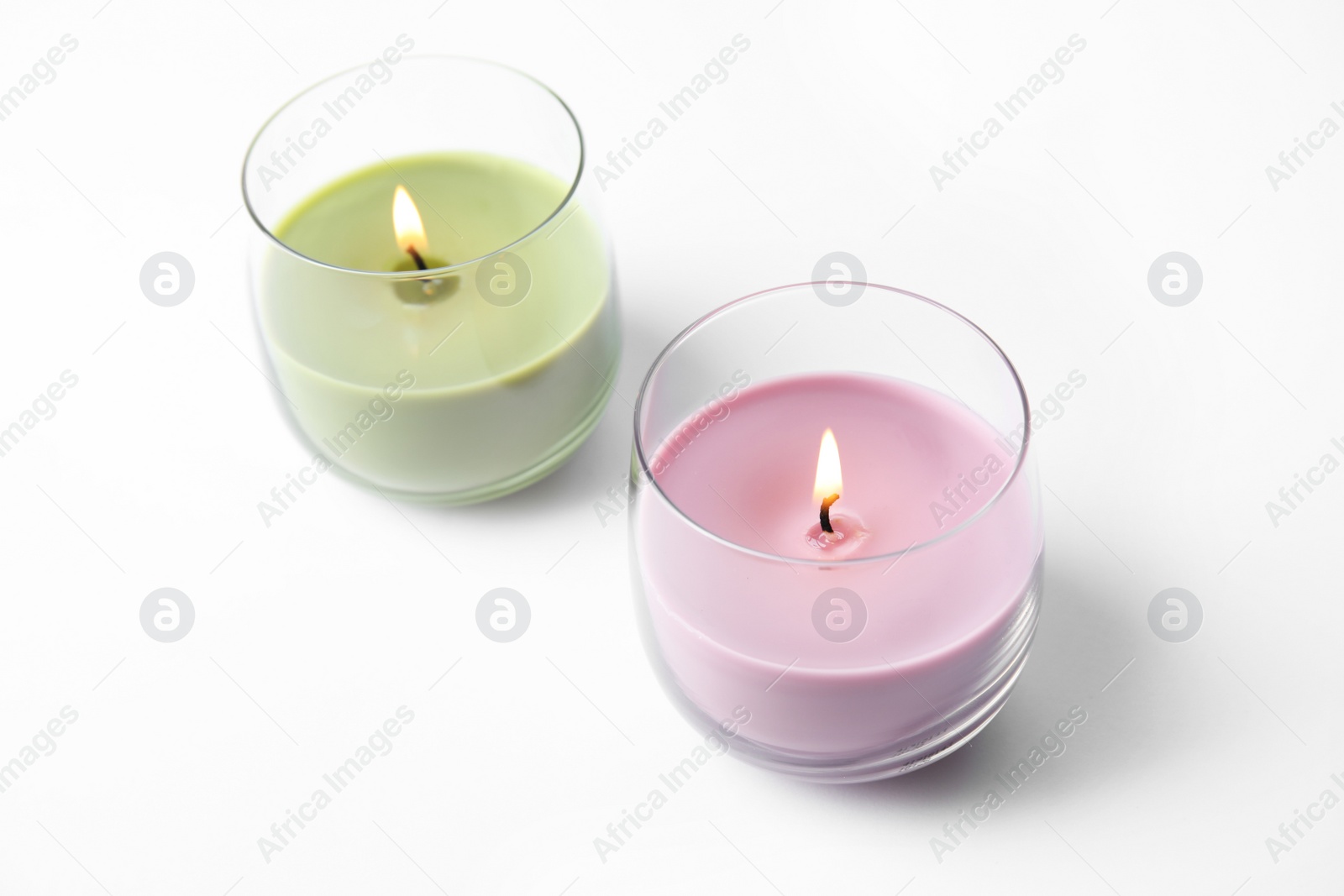 Photo of Color wax candles in glass holders isolated on white