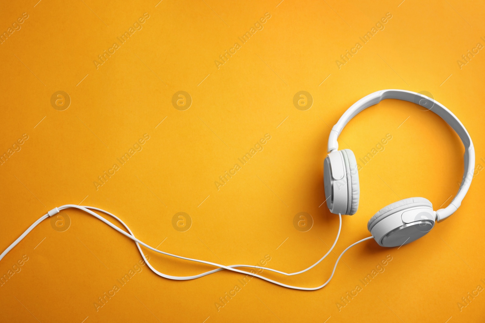 Photo of Stylish headphones on color background, top view. Space for text