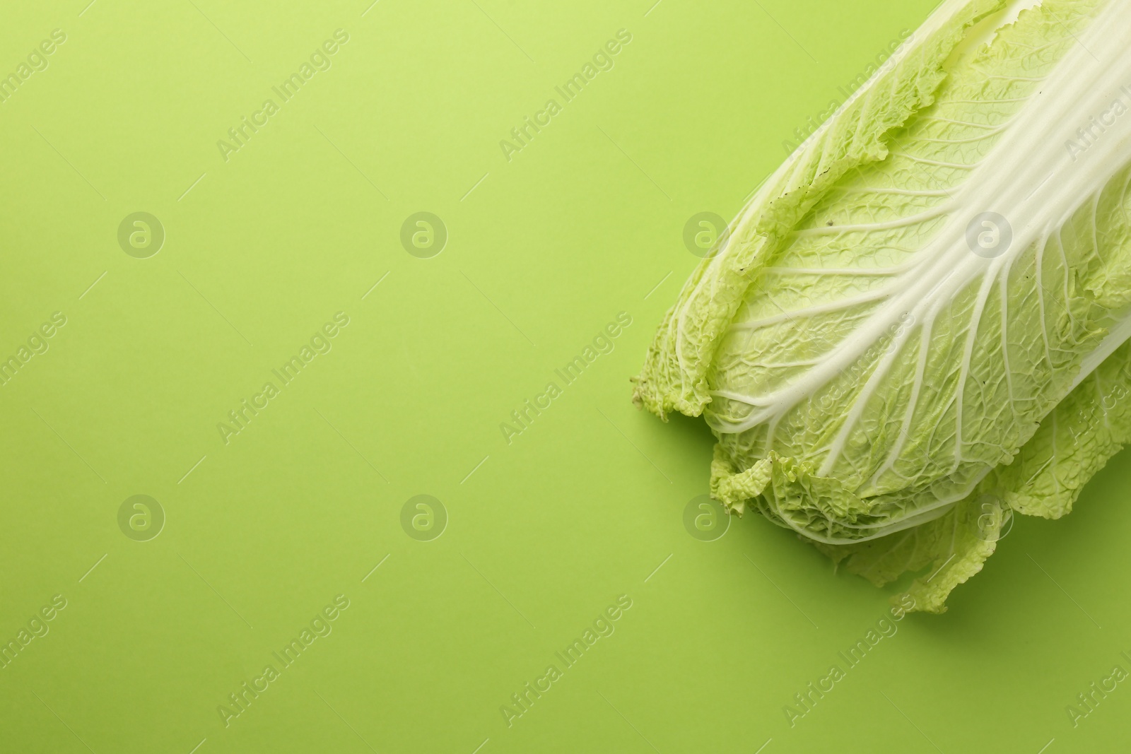 Photo of Fresh ripe Chinese cabbage on light green background, top view. Space for text