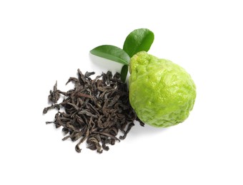 Photo of Pile of dry bergamot tea leaves and fresh fruit on white background, top view