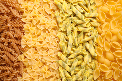 Different types of pasta as background, top view