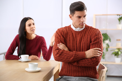 Photo of Couple with relationship problems at table in cafe