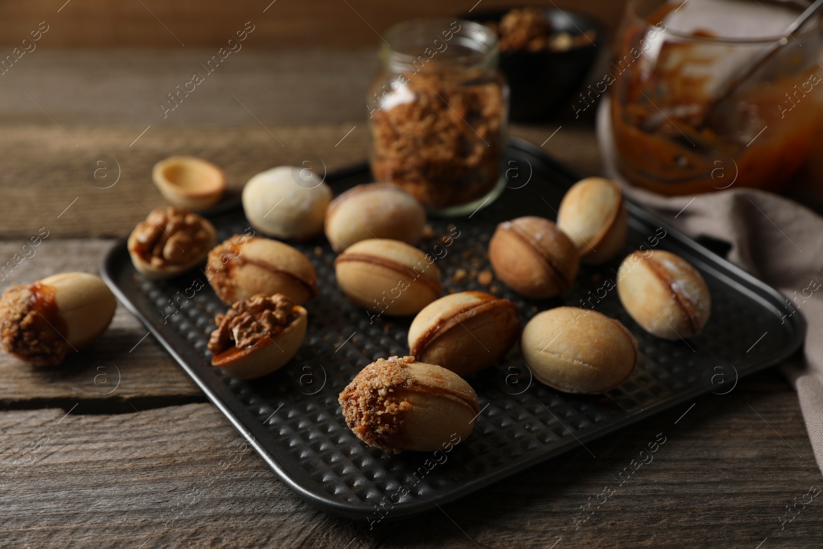 Photo of Freshly baked homemade walnut shaped cookies on wooden table, closeup