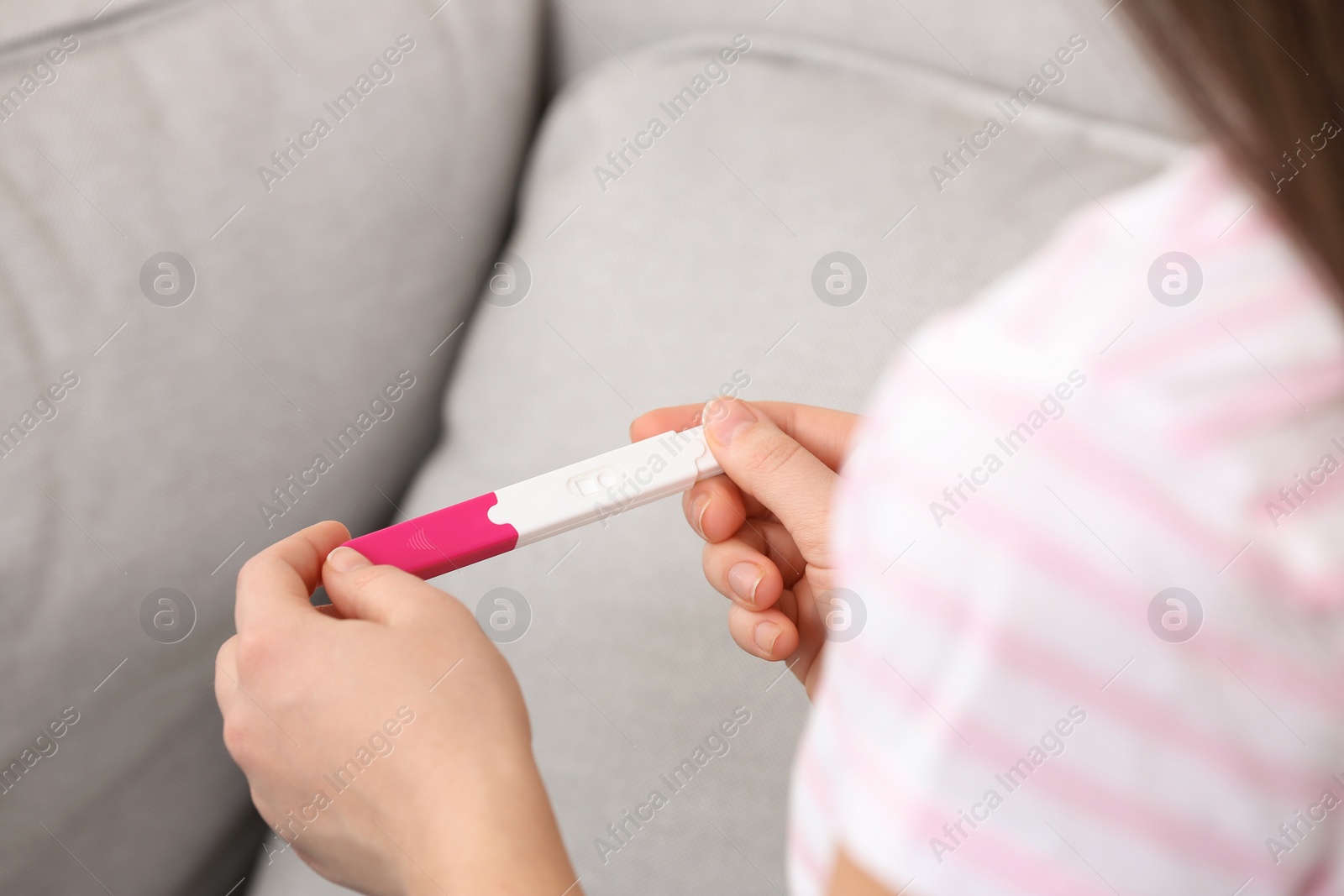 Photo of Young woman with pregnancy test indoors, closeup. Gynecology and childbirth