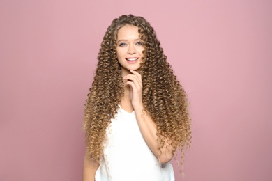 Photo of Portrait of beautiful young woman with shiny wavy hair on color background