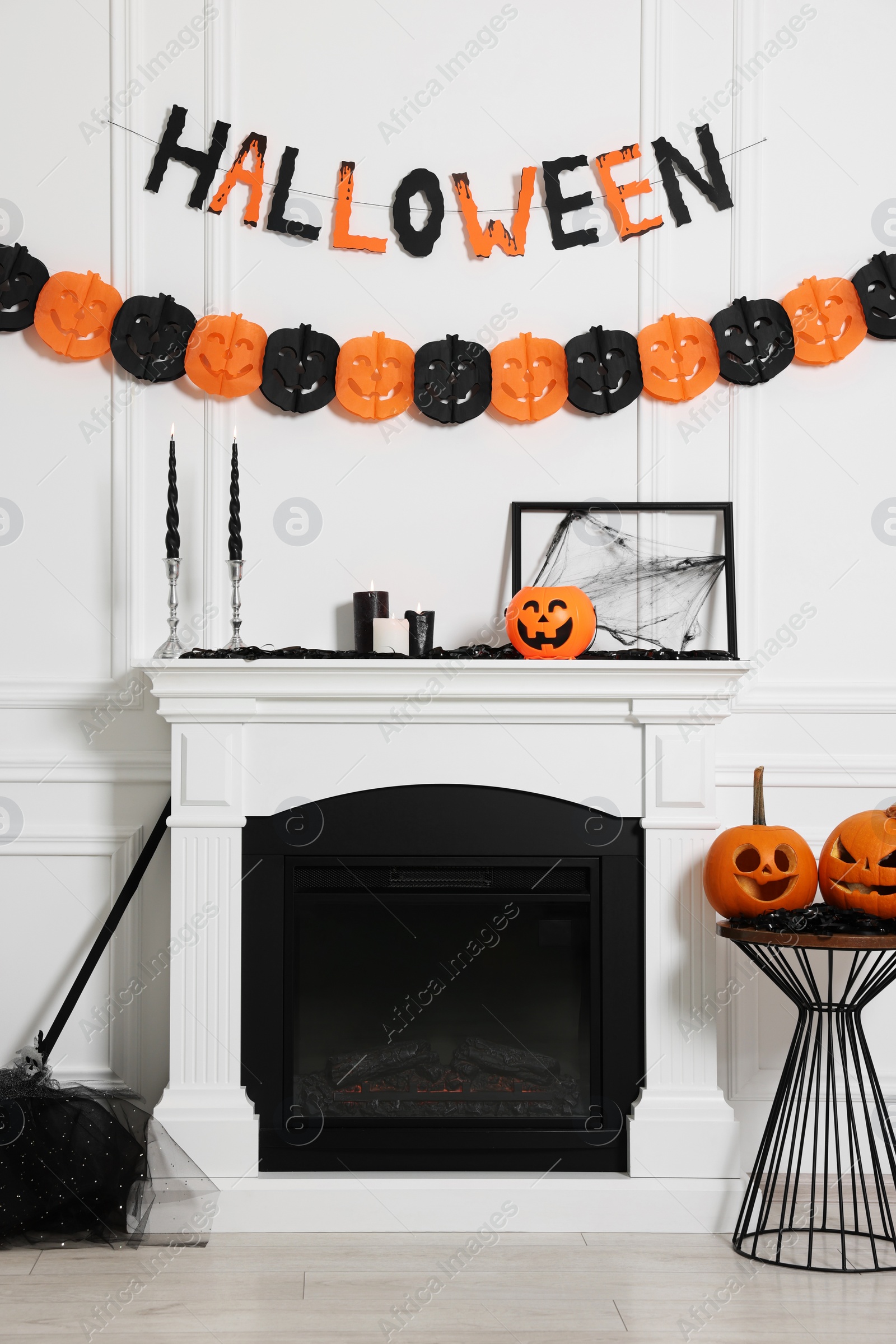 Photo of Stylish room with fireplace decorated for Halloween