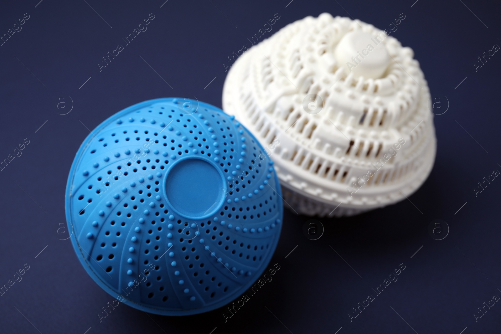 Photo of Dryer balls for washing machine on dark blue background, closeup