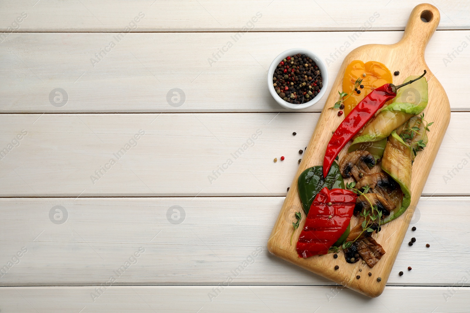 Photo of Delicious grilled vegetables served on white wooden table, flat lay. Space for text
