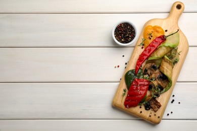 Delicious grilled vegetables served on white wooden table, flat lay. Space for text