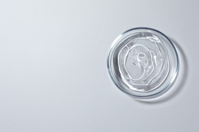Photo of Petri dish with liquid on white background, top view. Space for text